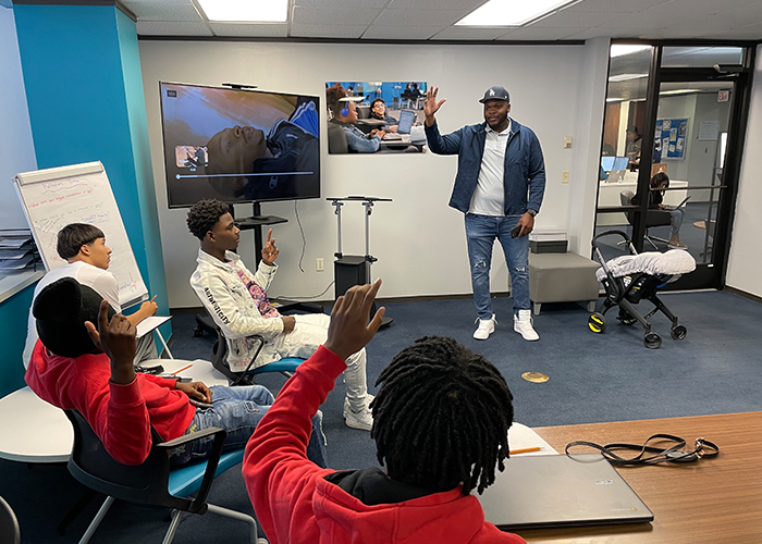 Man speaking to a group of young adults in an Ector County Acceleration Academies classroom