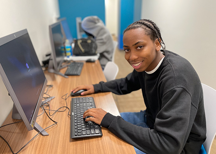 WAA GC Kaden smiling and working at computer